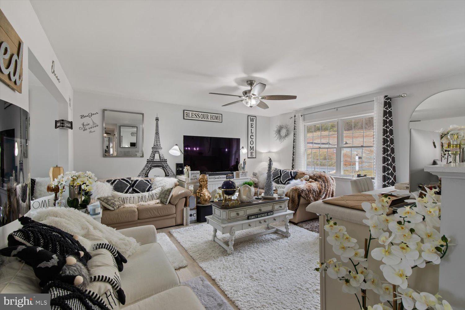 Living room with cream sectional sofas, patterned pillows, a decorative coffee table, and Eiffel Tower decor.