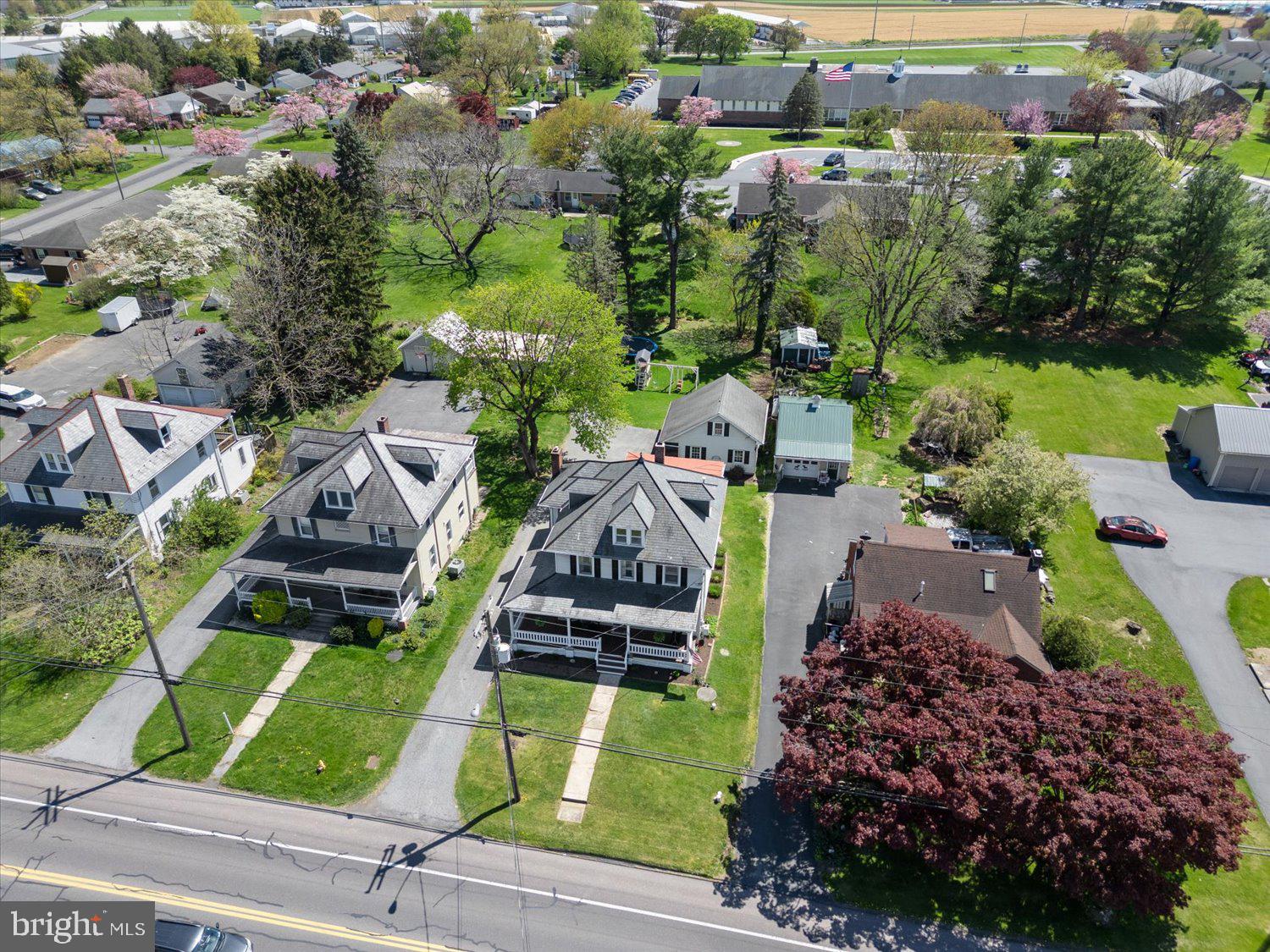 Aerial view of a Leola residential block with detached homes, mature trees, and a road in the foreground.