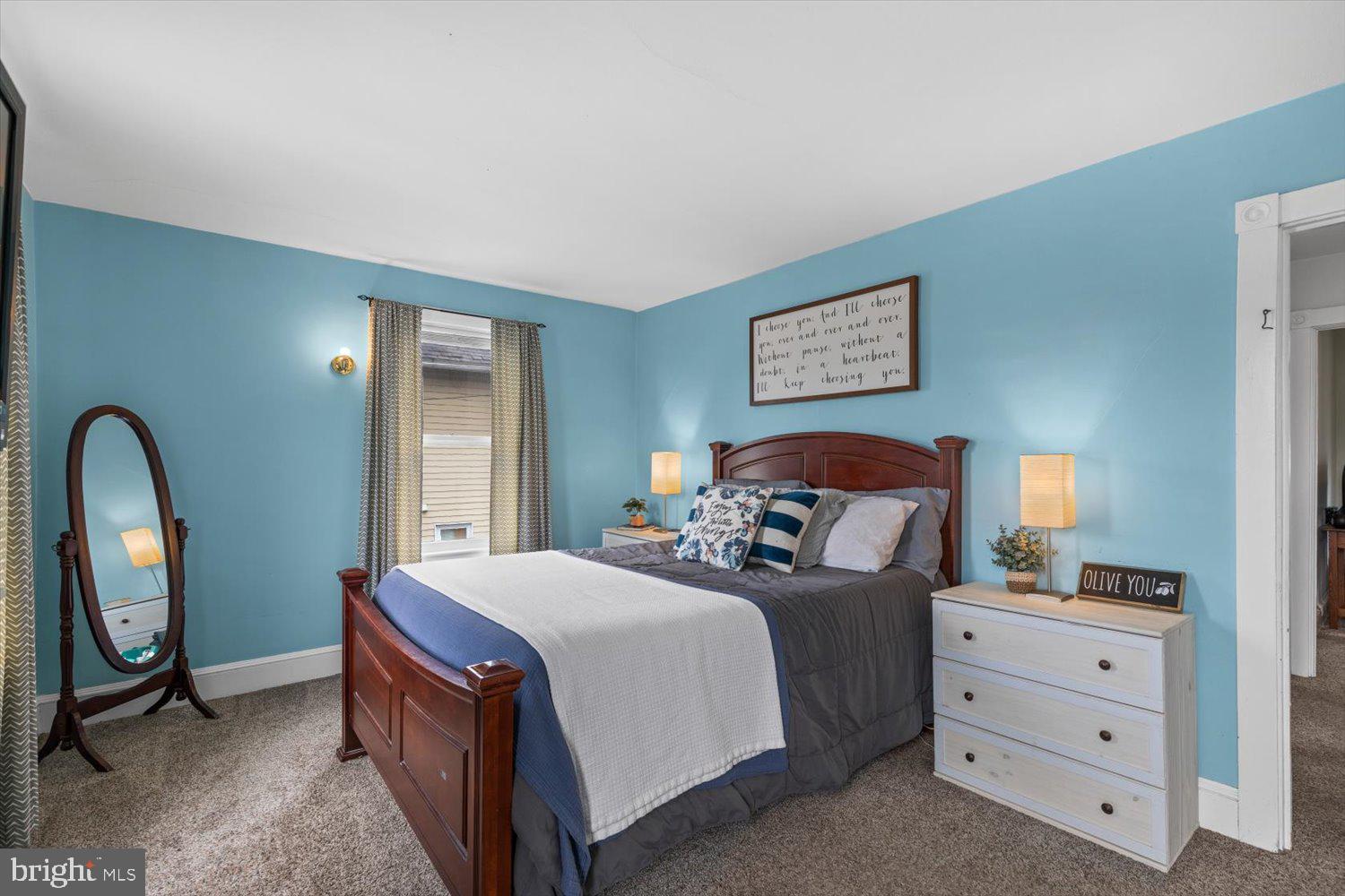 Bedroom with turquoise walls, a dark wood bed, gray bedding, and a white dresser.