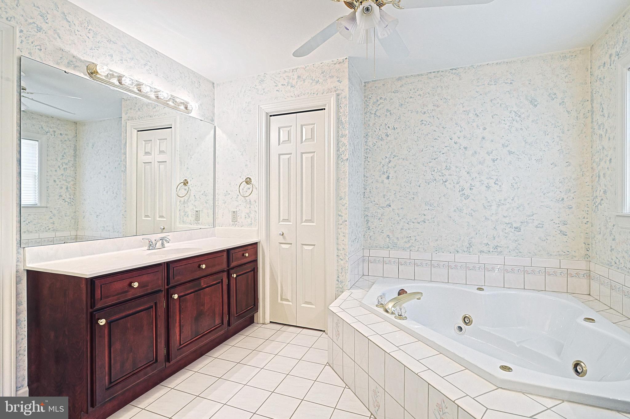 Bathroom with a dark wood vanity and a built-in corner jetted tub.