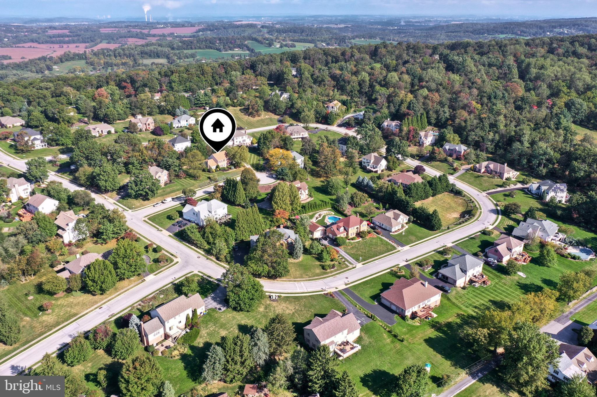Aerial view of a leafy neighborhood, with a house marker highlighting the listing location.