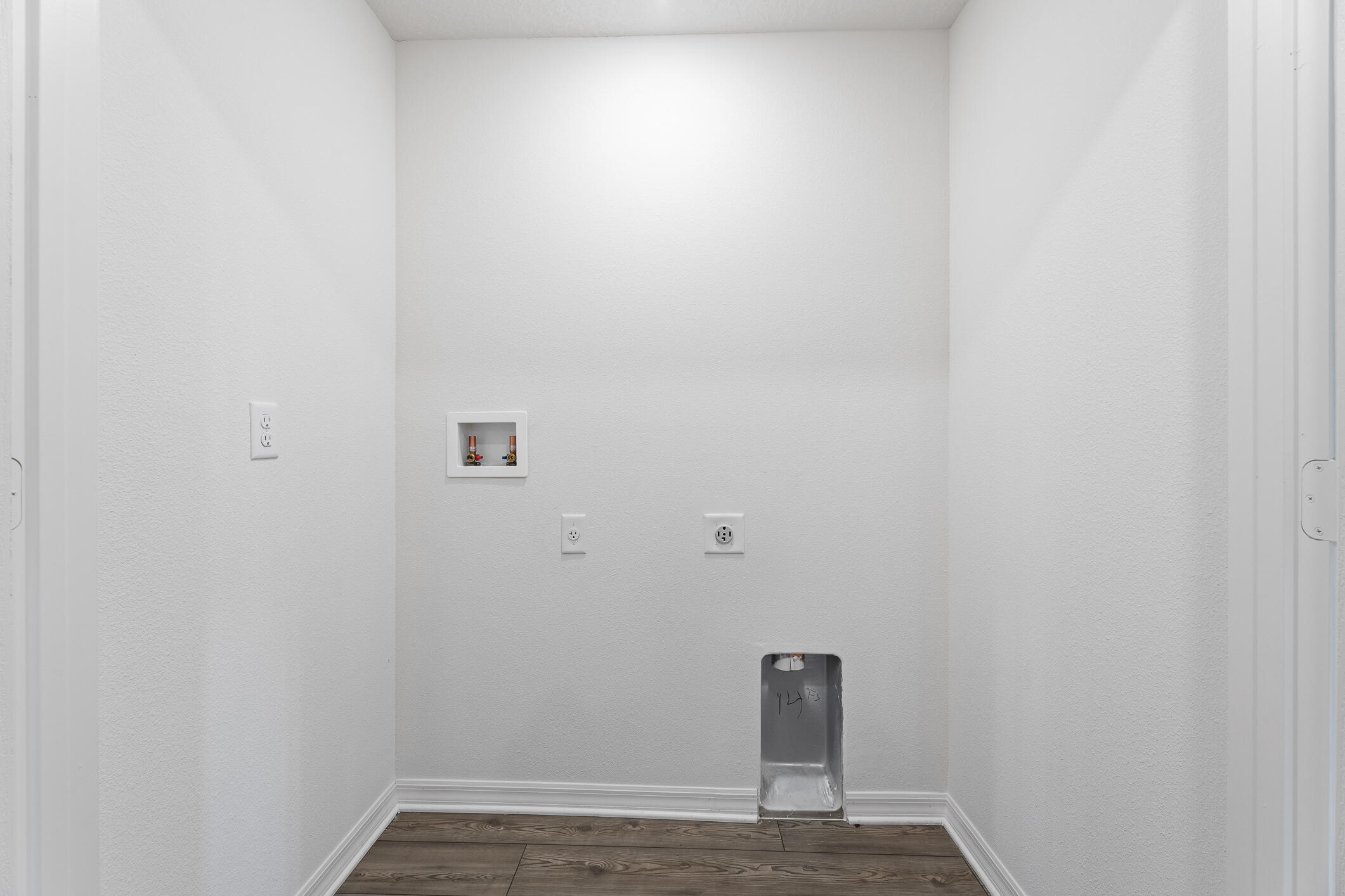 Laundry area with washer hookups, electrical outlets, and a recessed dryer vent.