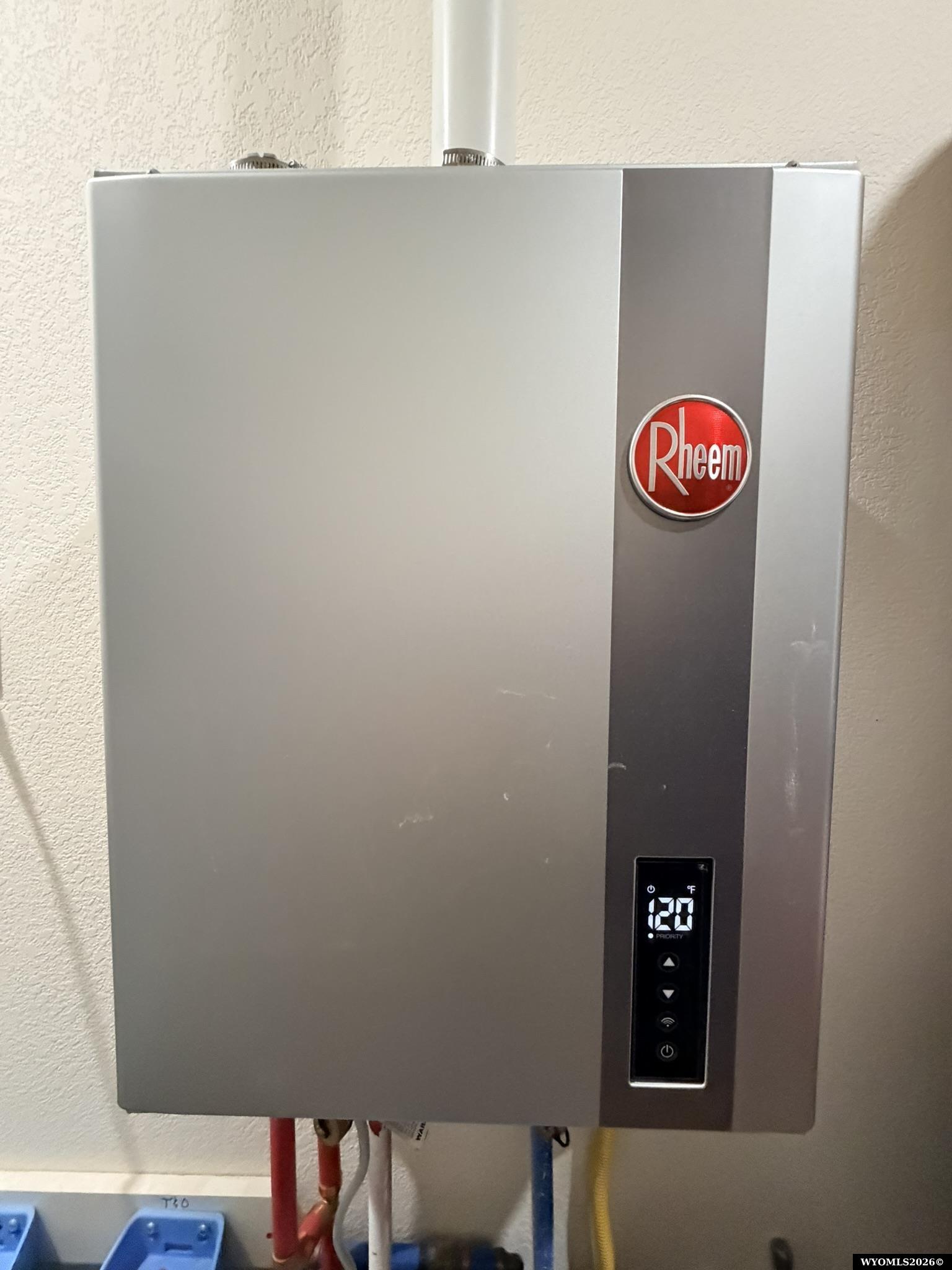 Wall-mounted Rheem tankless water heater with a digital temperature display.