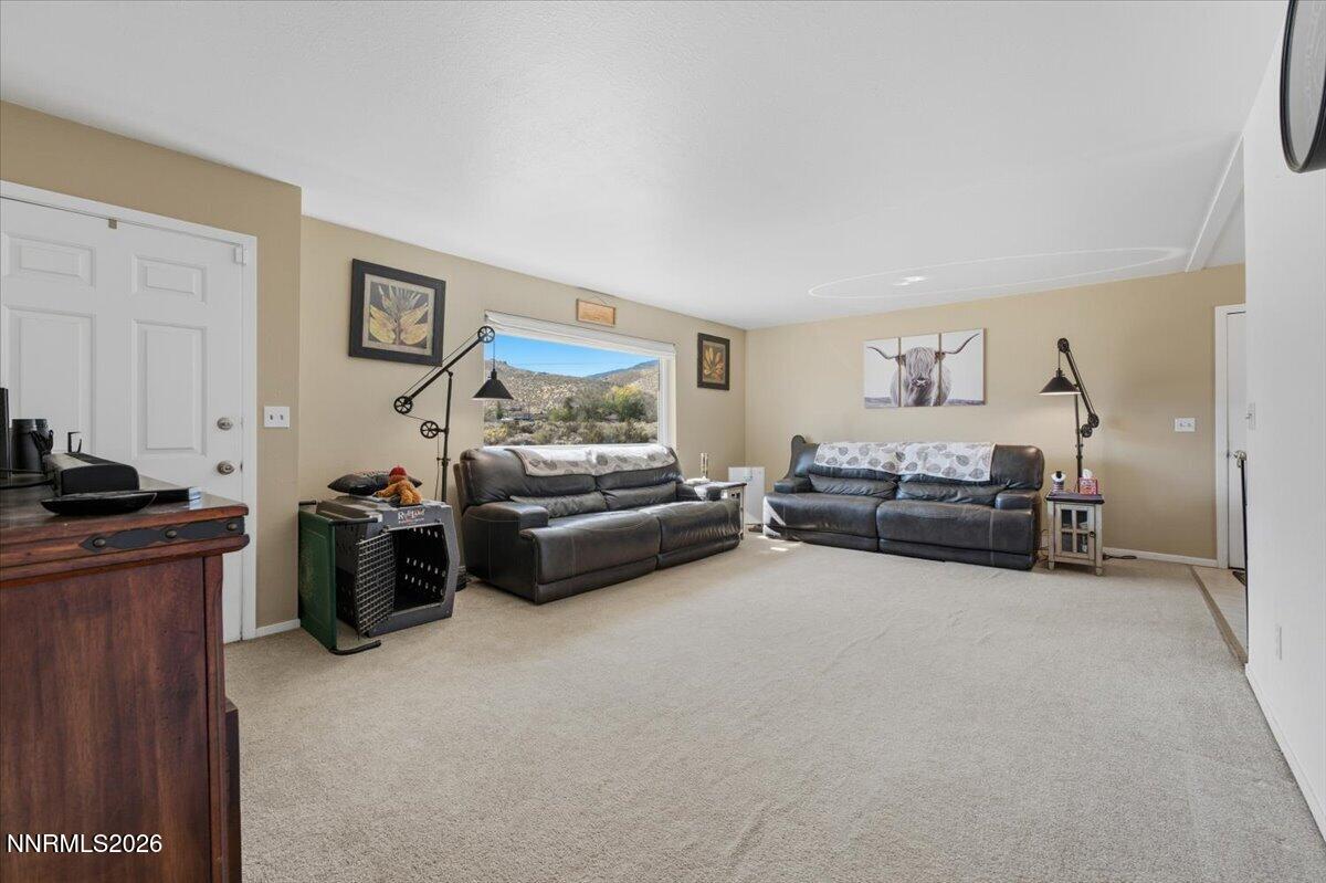 Living room with two leather sofas and a large window overlooking mountains.
