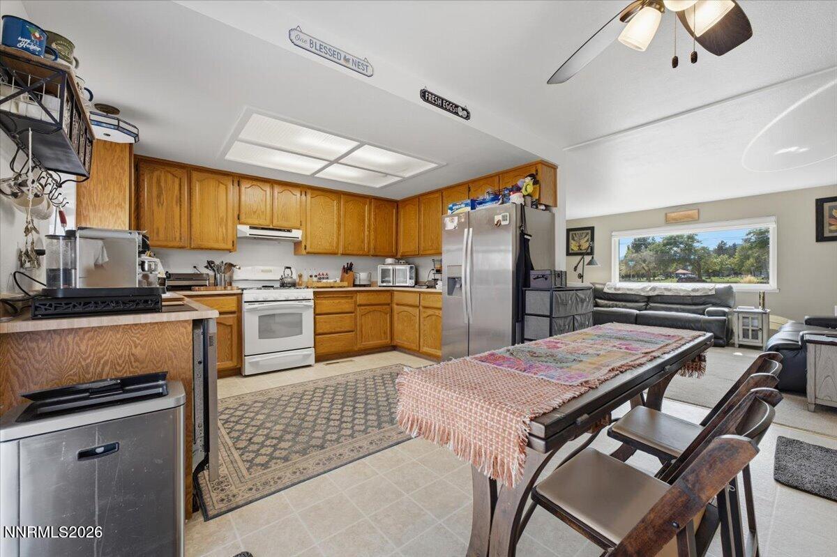 Kitchen and dining area with wood cabinets, stainless appliances, and an adjoining living room.