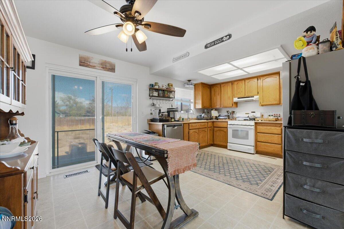 Kitchen and dining area with wood cabinets, a dining table, and a sliding glass door.