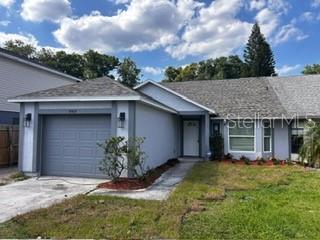 Gray single-story home with a two-car garage, driveway, and front lawn.