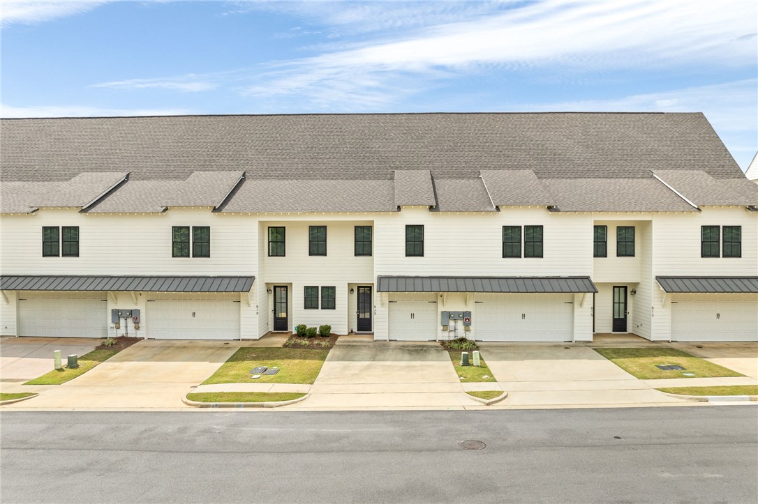 Row of two-story townhomes with attached garages and concrete driveways.