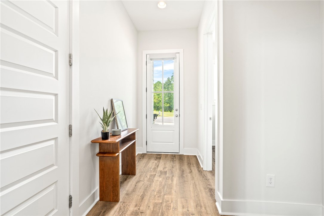 Entry hall with wood-look flooring and a wooden console beside the glass-paneled front door.