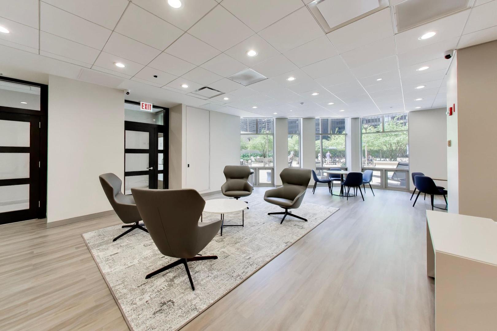 Condominium lounge with sculptural armchairs and courtyard-facing windows.