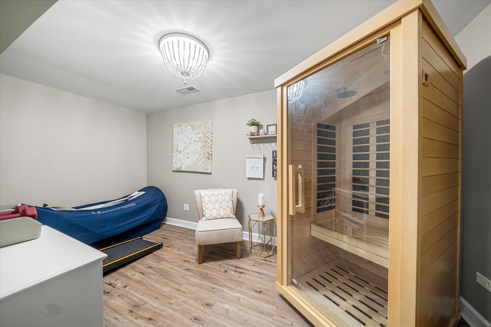 Home wellness room with a glass-fronted wooden sauna and exercise equipment.
