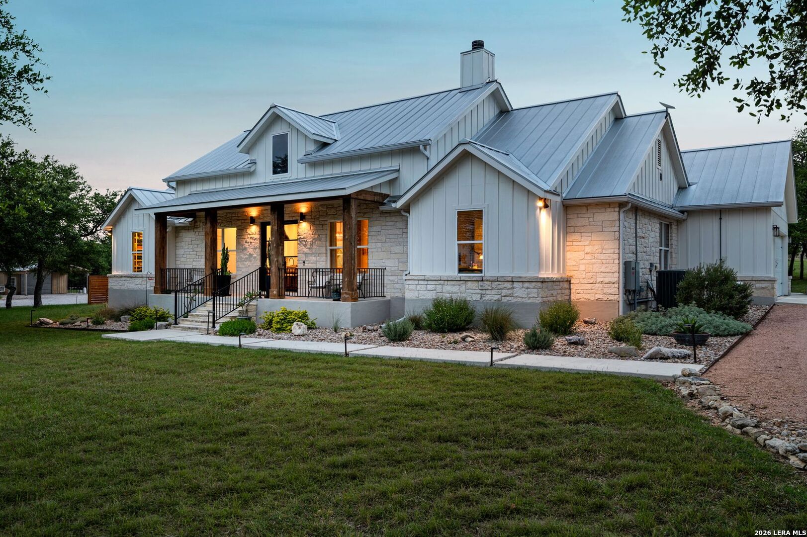 Home at 2009 Axis Circle with a stone facade, metal roof, and warmly lit covered porch.