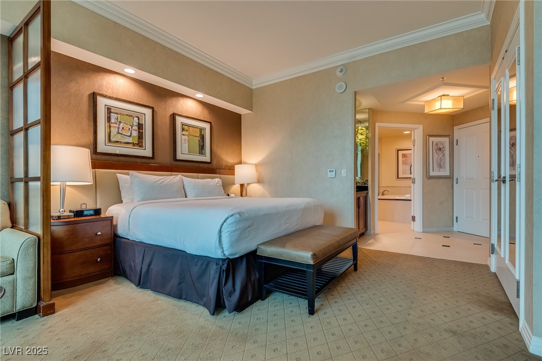 Bedroom with a king-size bed, framed artwork, and an open doorway to the bathroom.