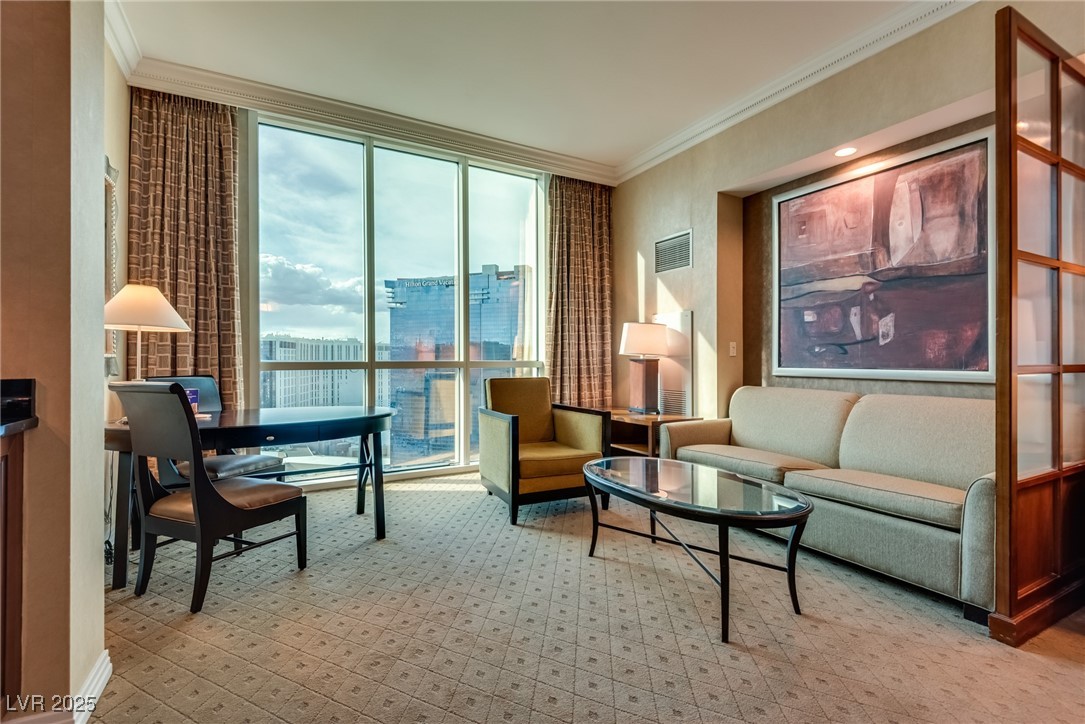 Furnished living room with floor-to-ceiling windows overlooking the Las Vegas skyline.