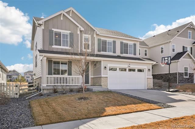 Two-story gray home with a covered porch, attached garage, and basketball hoop by the driveway.