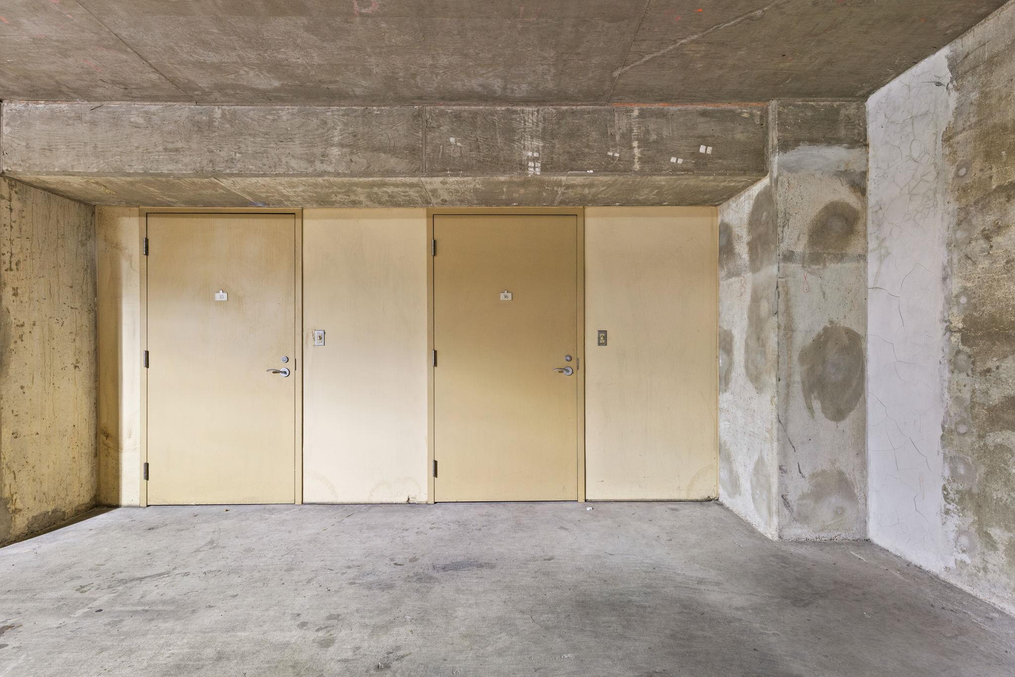 Concrete garage alcove with two beige storage doors numbered 35 and 36.