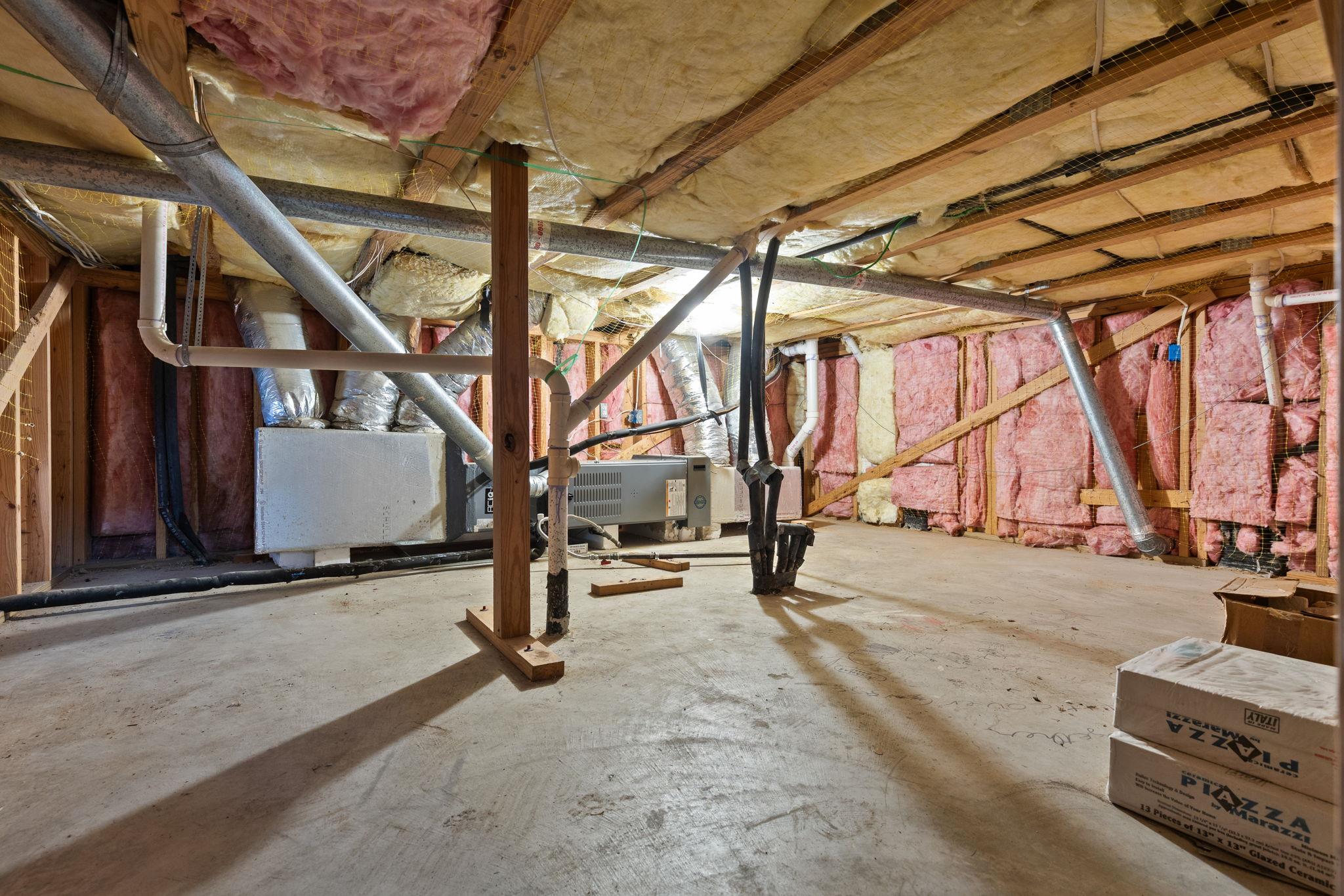 Unfinished basement utility area with exposed insulation, HVAC equipment, and ductwork.