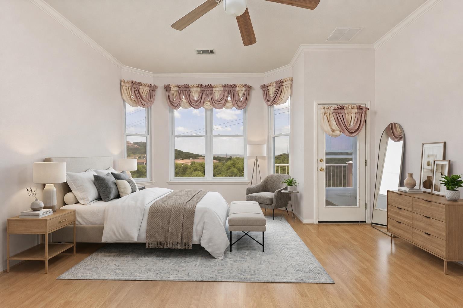 Furnished bedroom with a king-size bed, tall windows, and views of green hills.