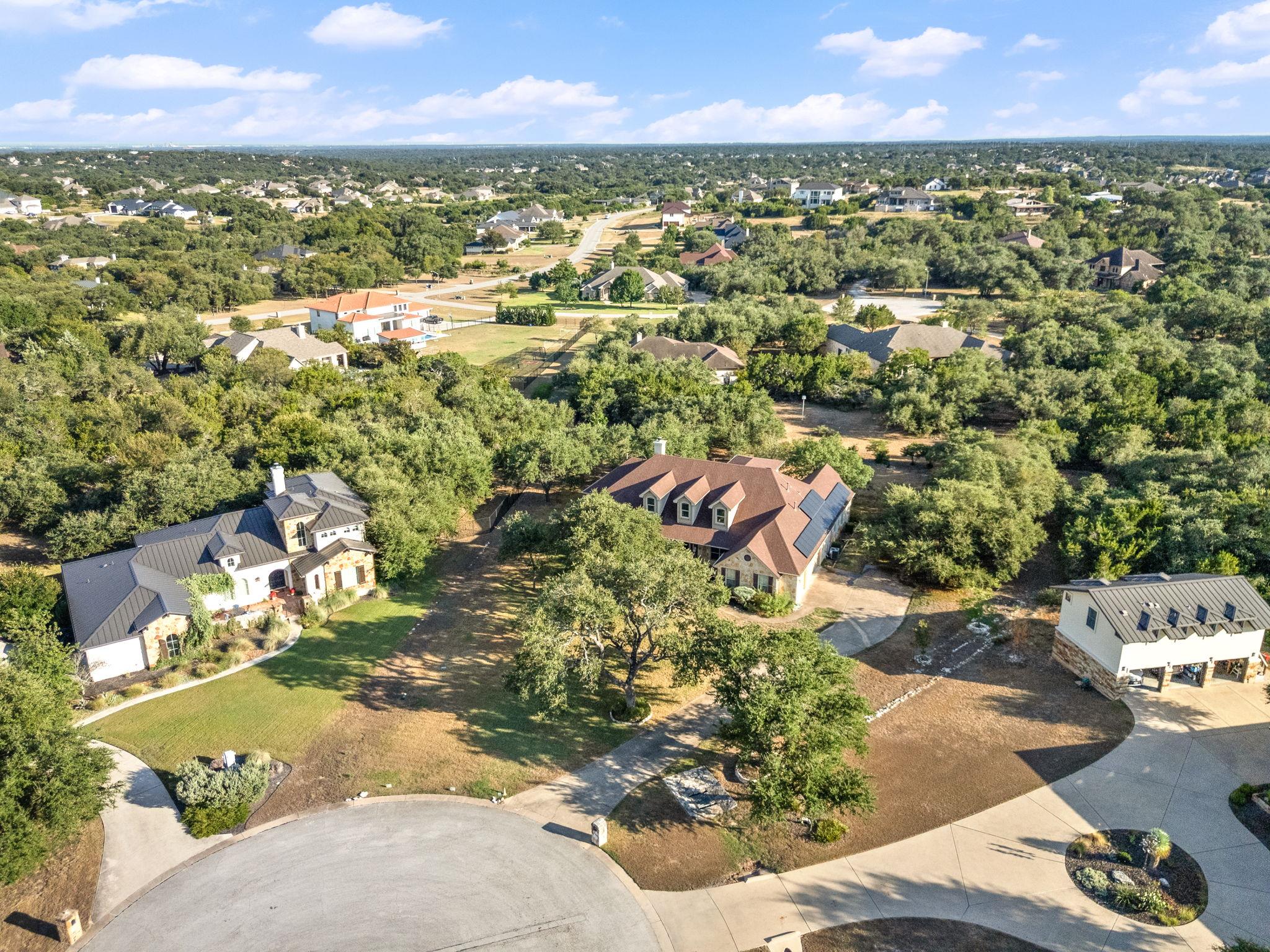 Aerial view of homes on wooded lots around a cul-de-sac.
