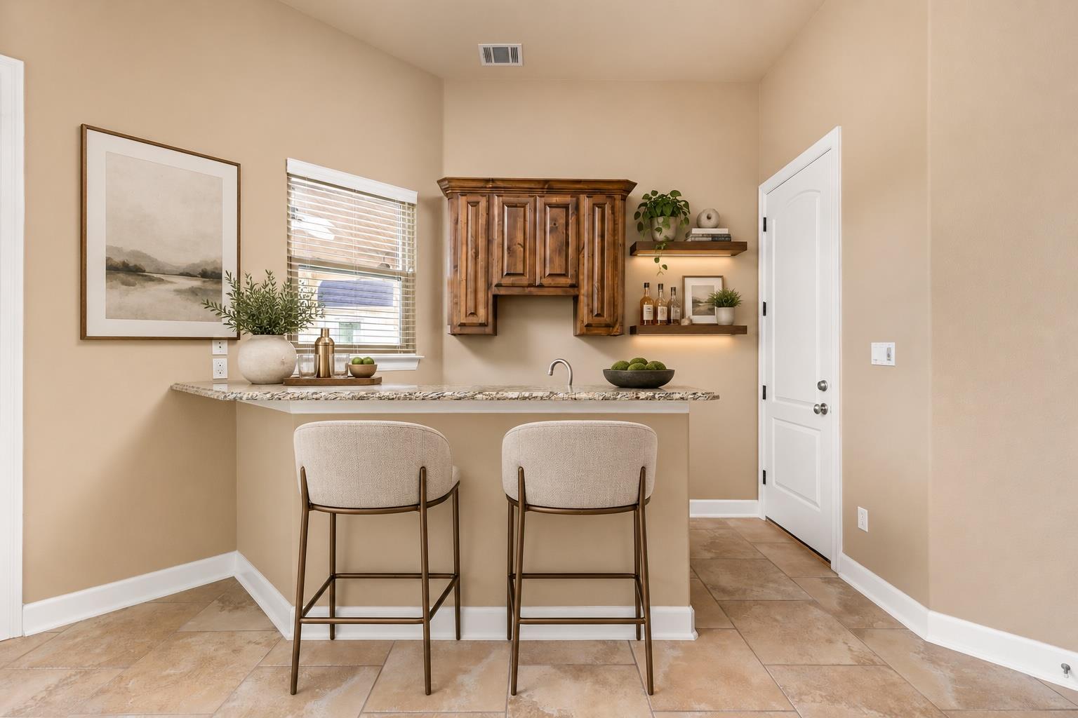 Kitchen counter with two upholstered bar stools, dark wood cabinets, and open display shelves.