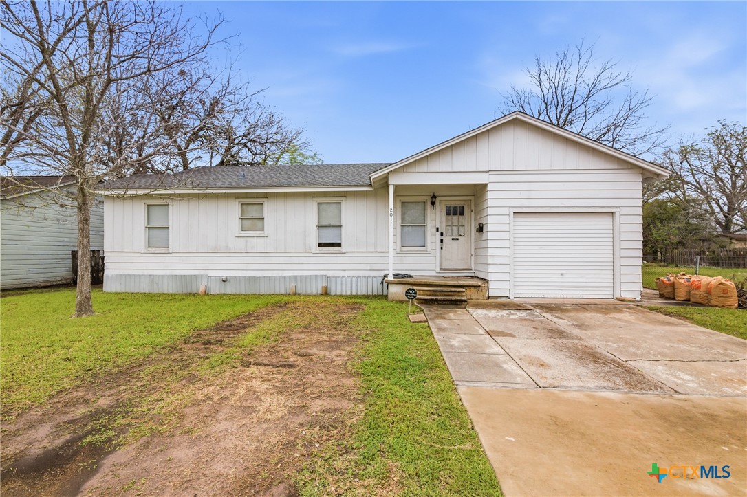 Single-story white house with an attached garage, front porch, and concrete driveway.
