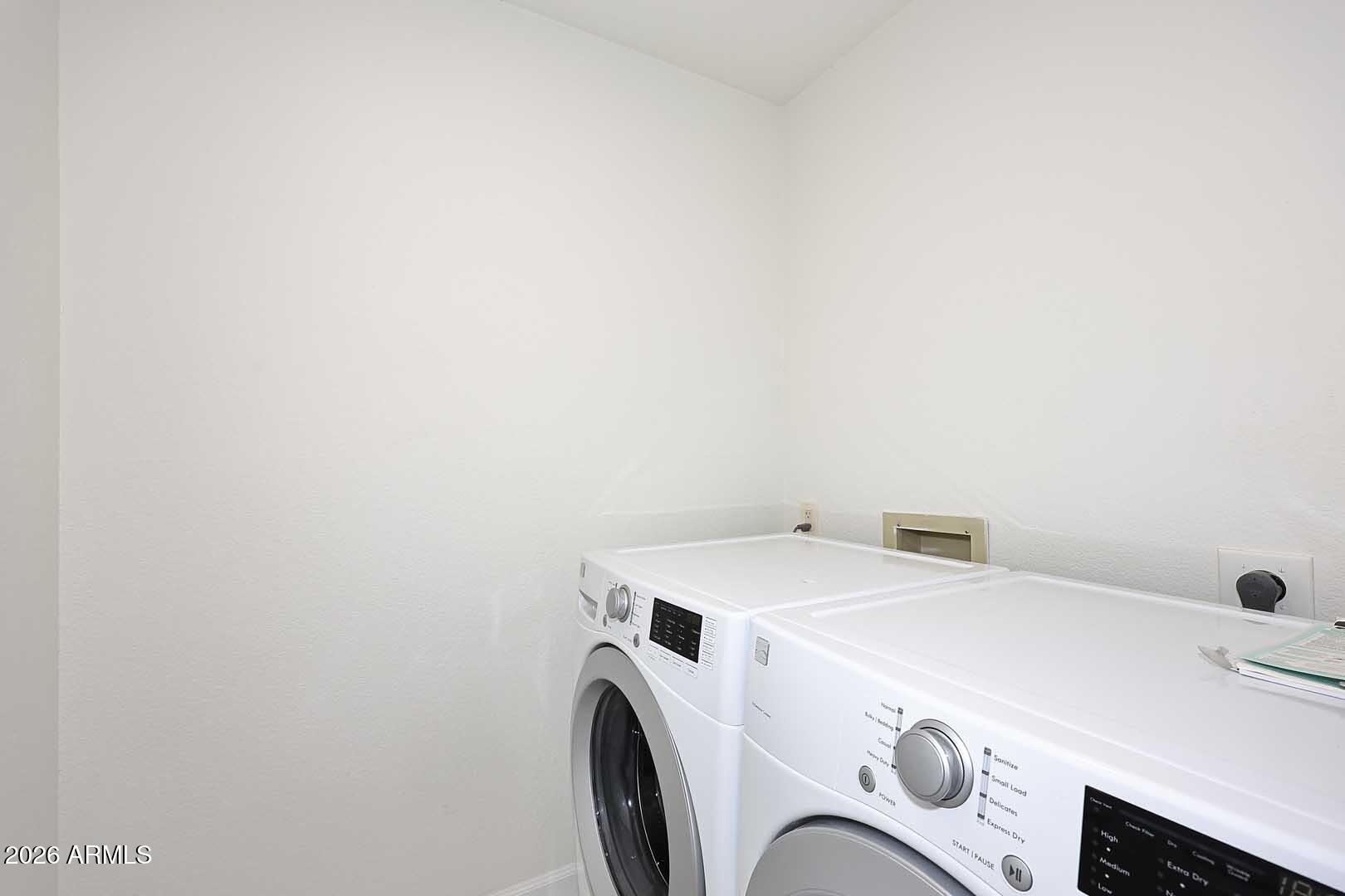 Laundry room with white front-loading washer and dryer.