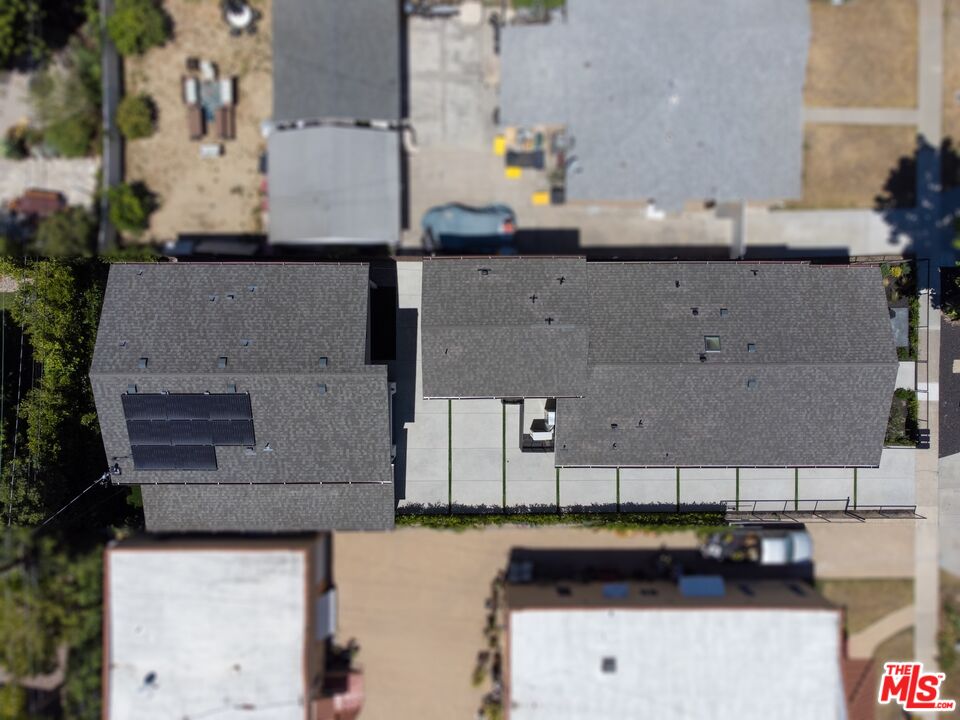 Aerial view of a single-story home with gray roofs and solar panels.