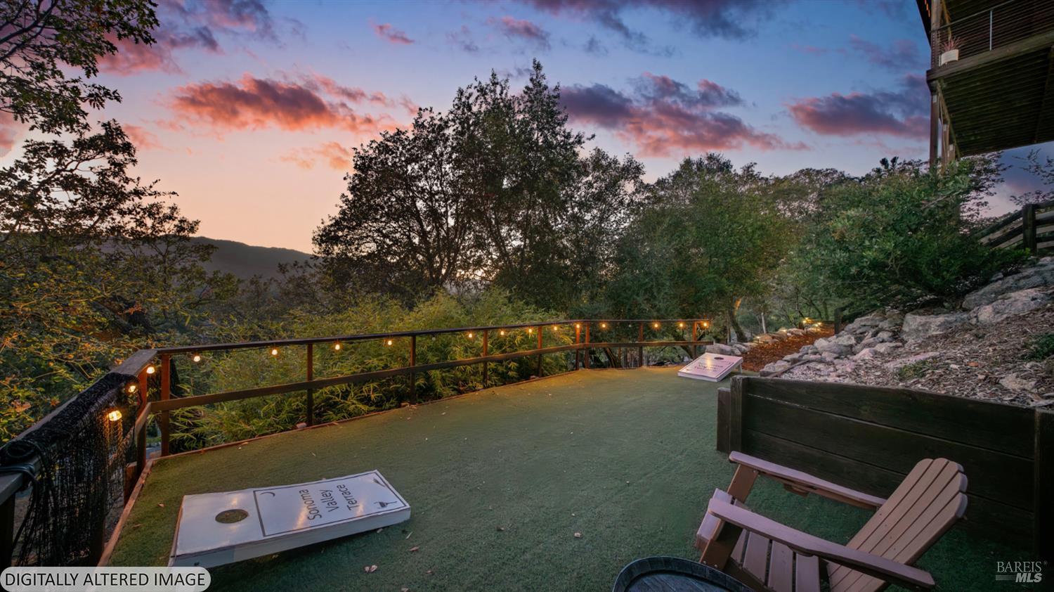 Outdoor terrace with Adirondack chairs and string lights overlooking wooded hills at dusk.