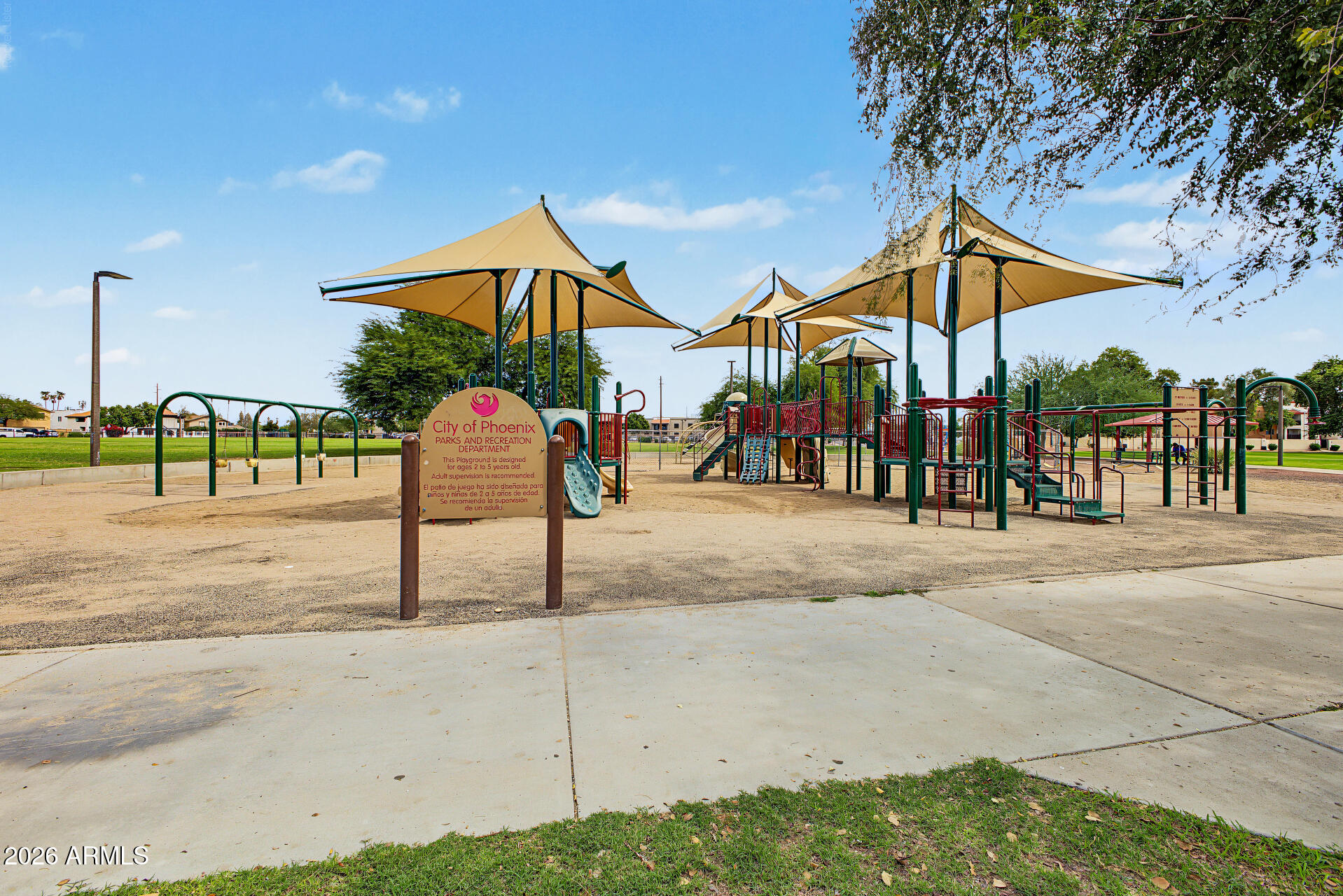 Phoenix park playground with slides and swings beneath large shade sails.