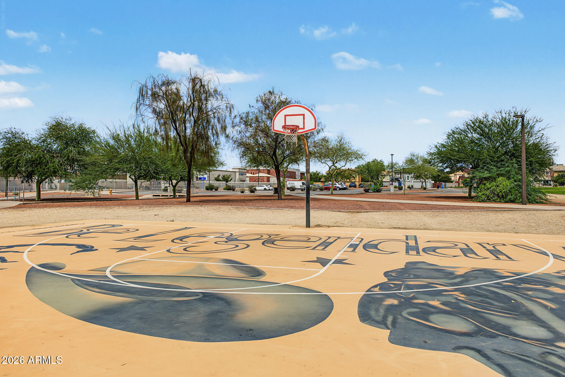 Basketball court with a red-and-white hoop and large painted graphics on the pavement.