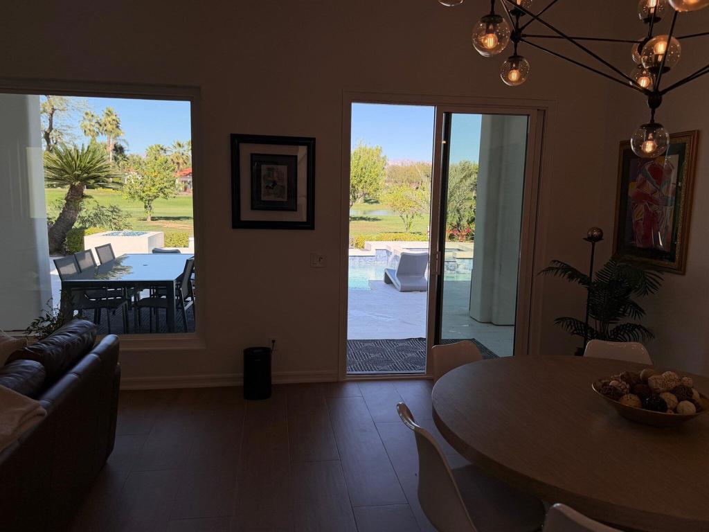 Dining area with a round table and sliding doors opening to a poolside patio.