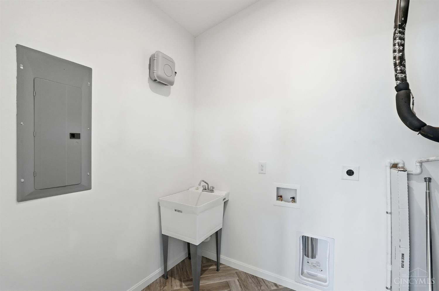 Laundry room with a deep utility sink, washer hookups, and water filtration unit.