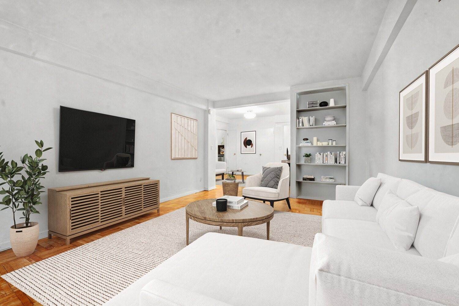 Bright living room with white sofas, built-in bookshelves, and a TV above a wood media console.