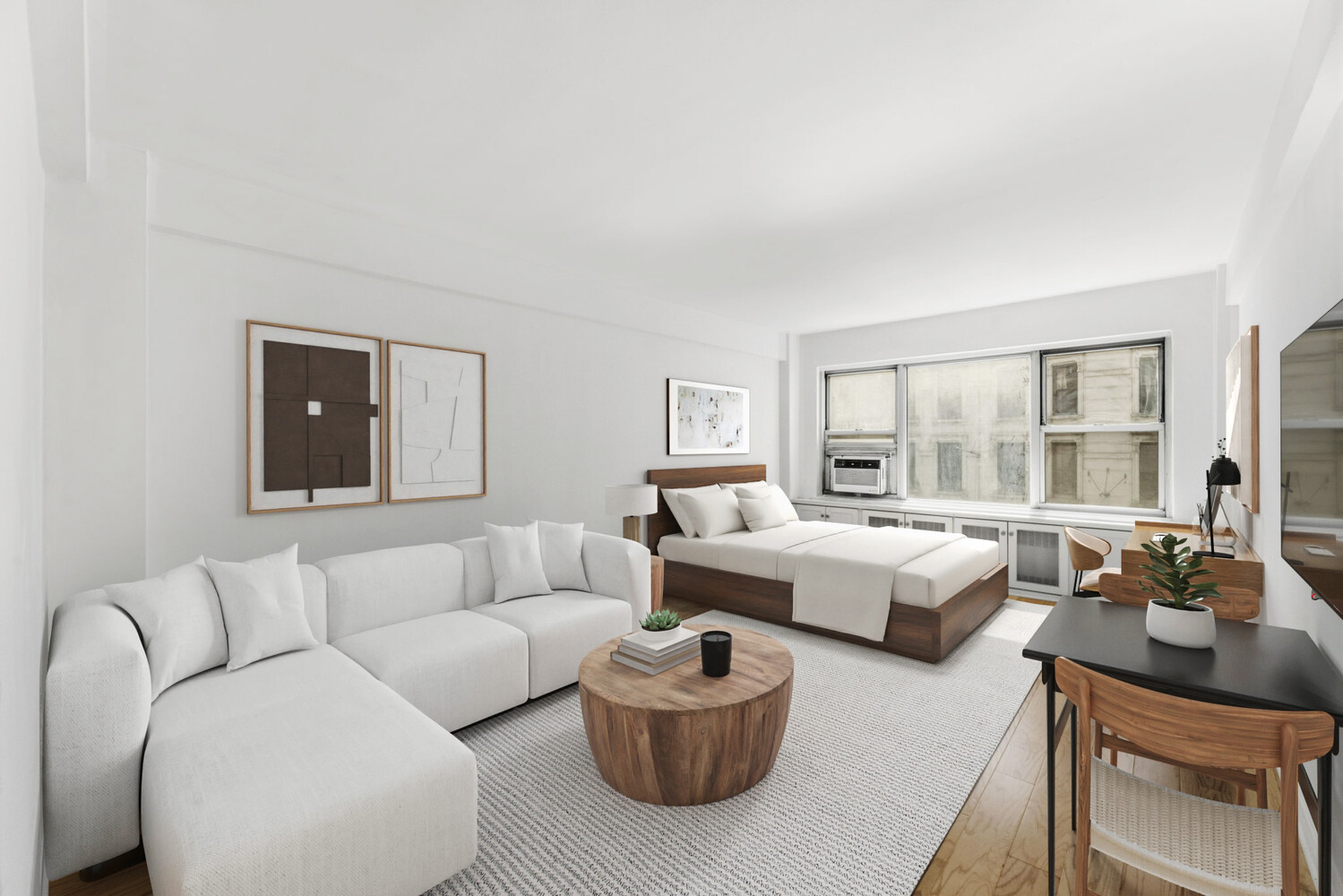 Furnished studio apartment with a white sectional, wood-platform bed, and large windows.