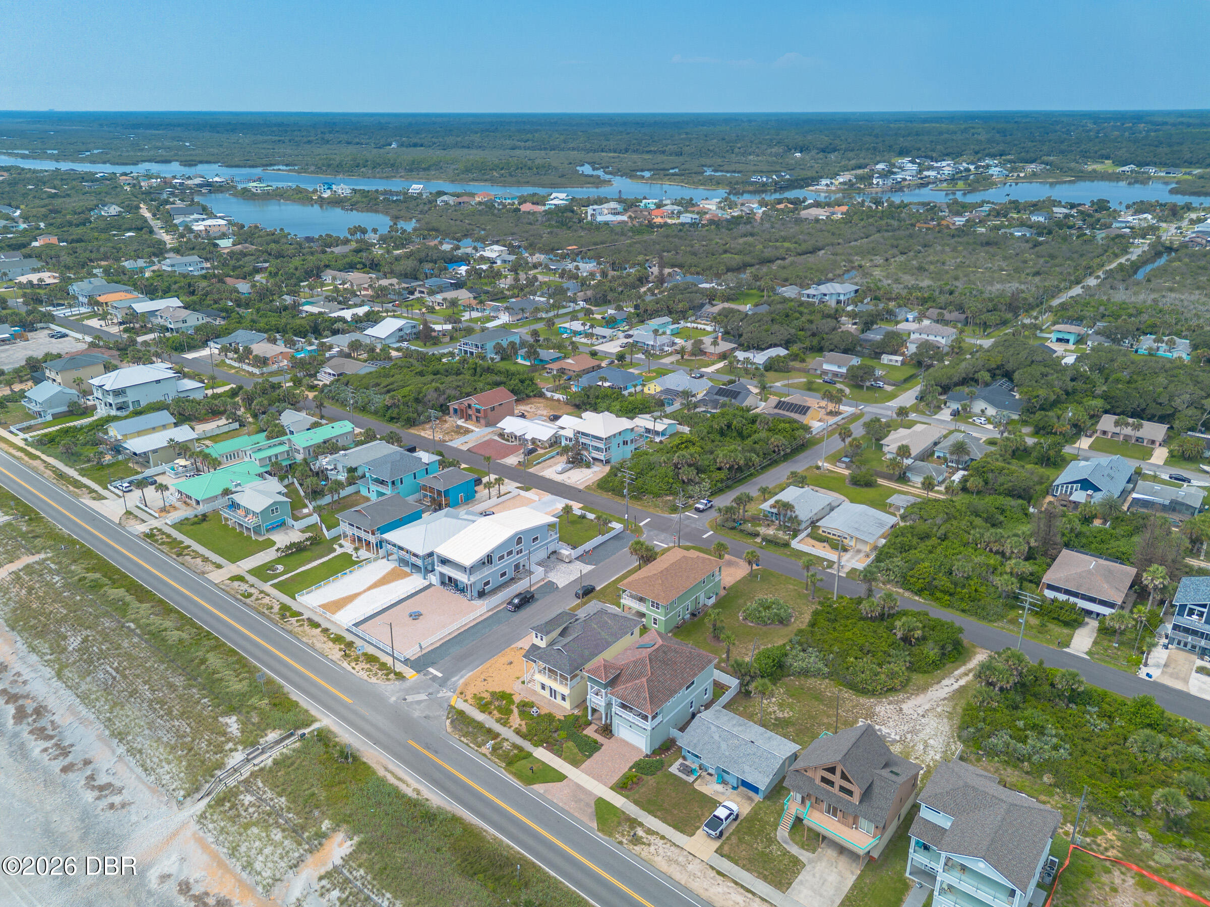 Aerial view of coastal homes along Ocean Shore Boulevard, with the beach road and waterways inland.