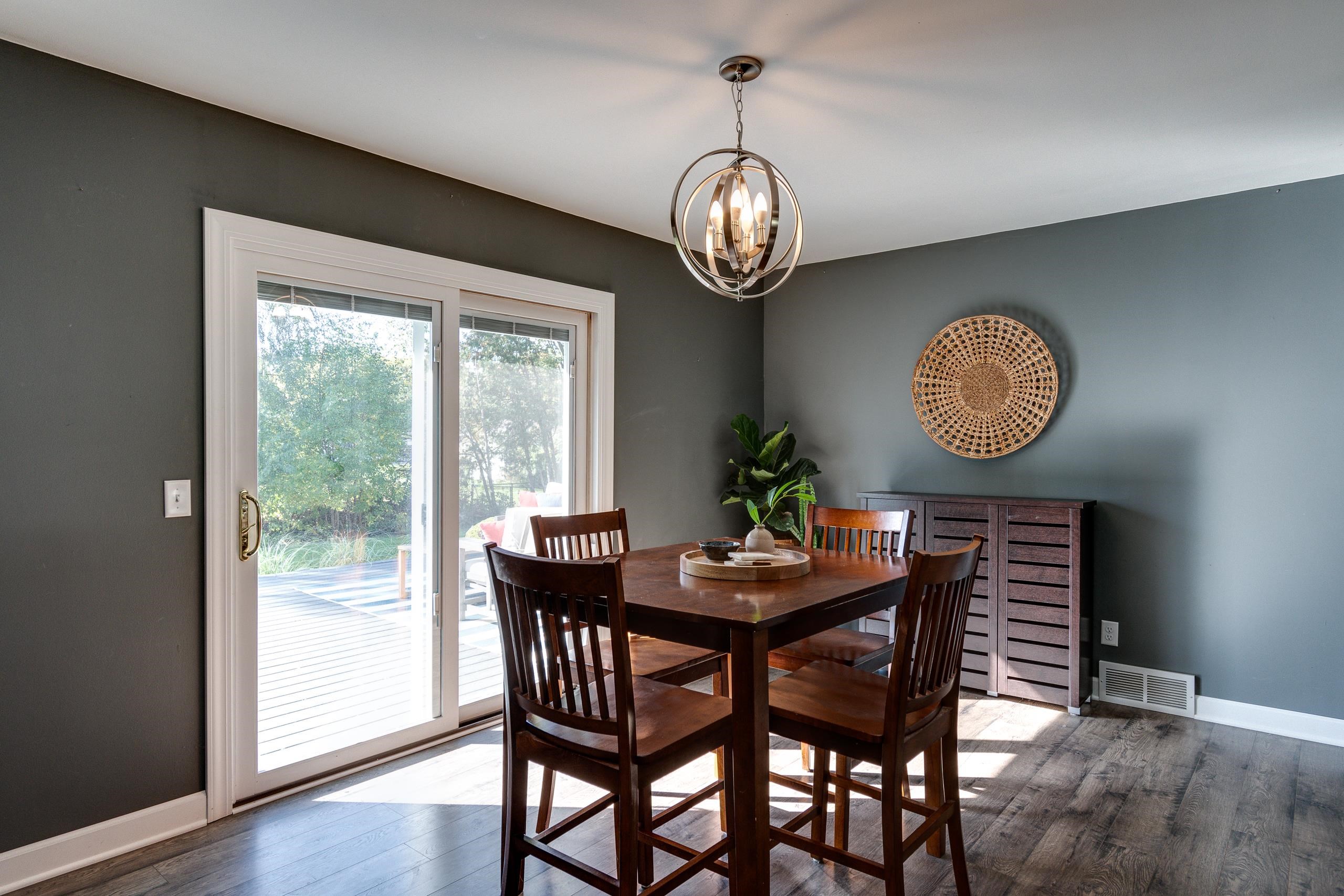 Dining room with a dark wood table beside sliding glass doors to a deck.