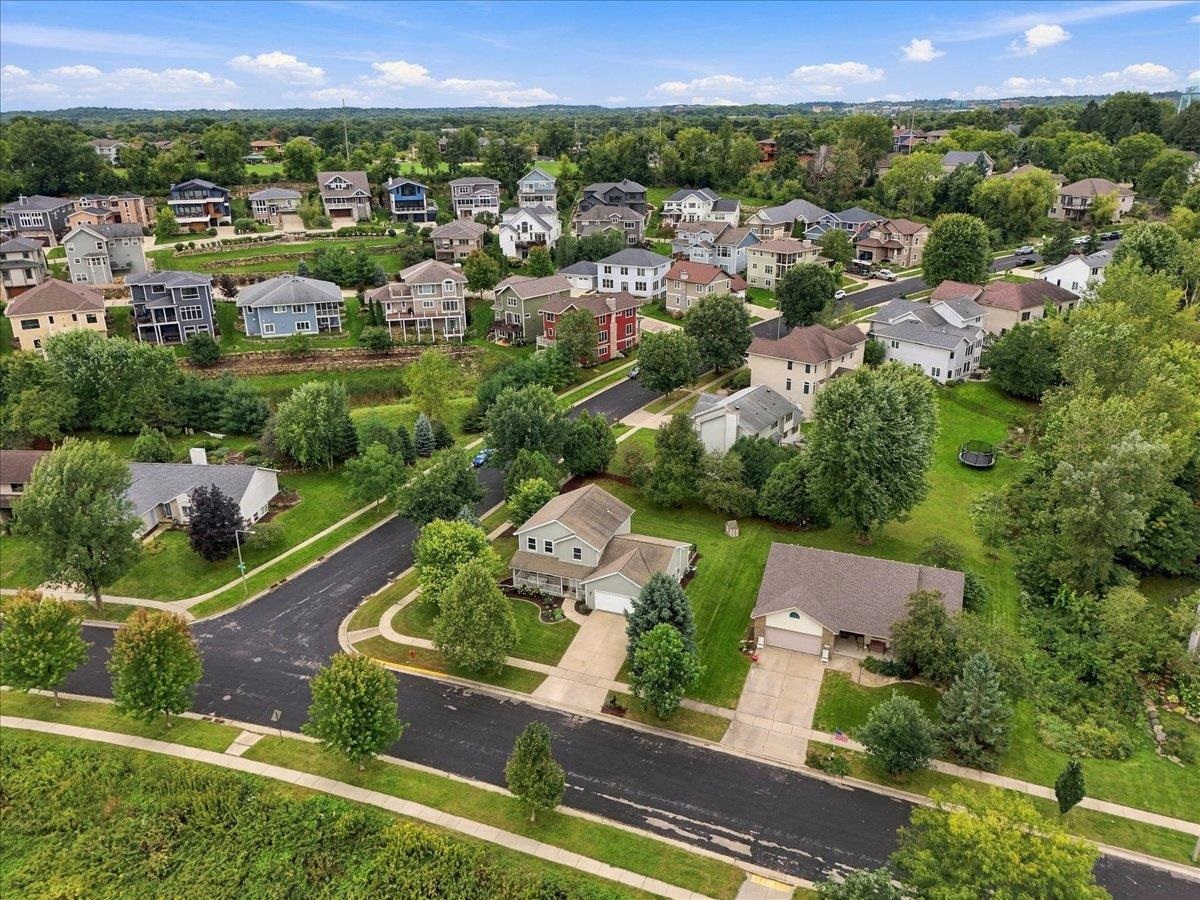 Aerial view of a tree-lined residential neighborhood with detached homes and curving streets.
