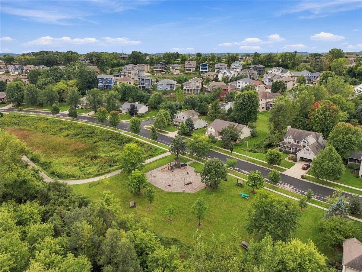 Aerial view of a residential neighborhood beside a grassy park and playground.