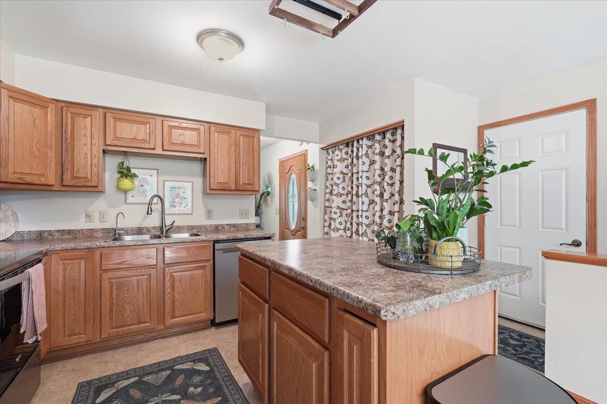 Kitchen with wood cabinets and a large island topped with a plant and fruit bowl.