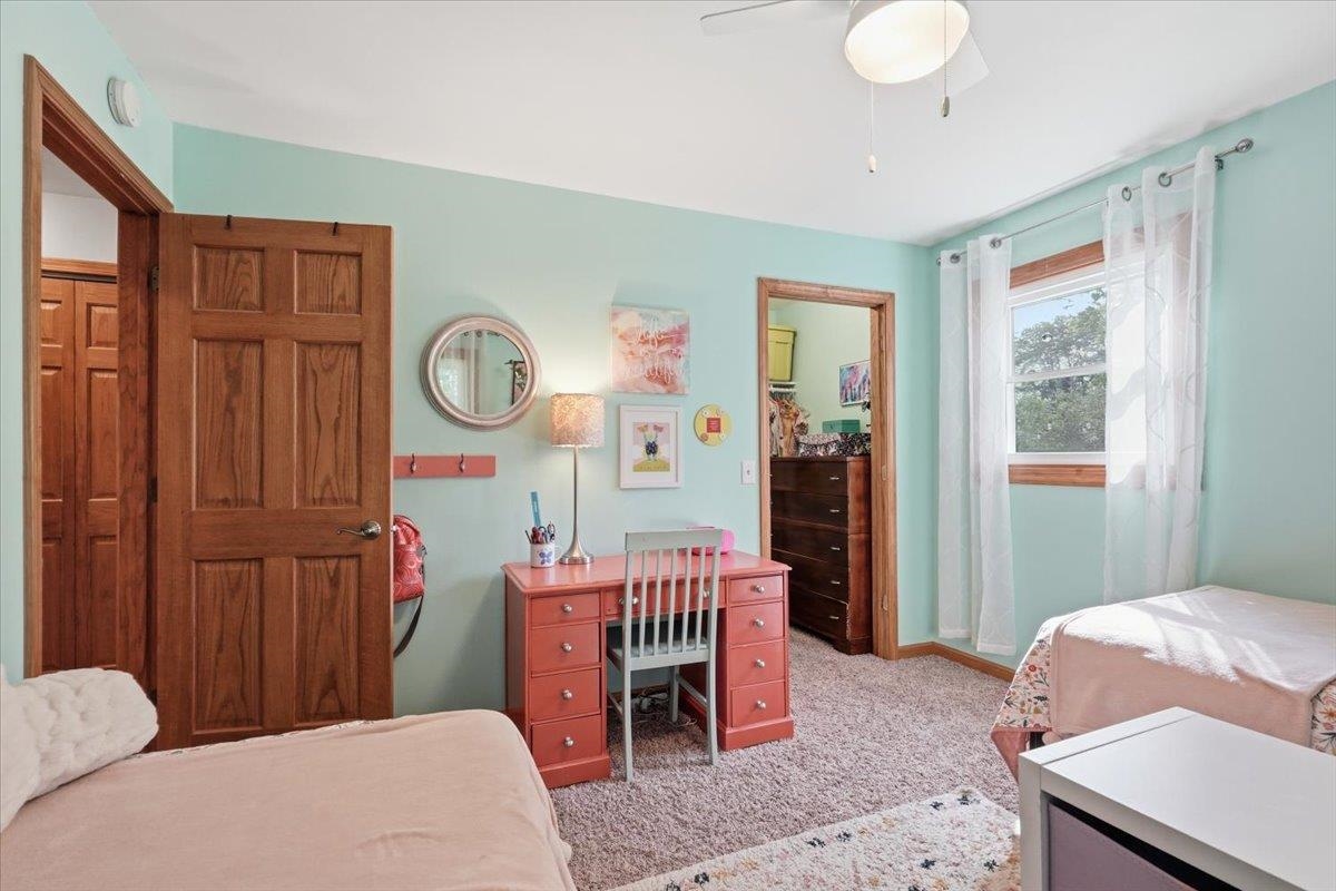Bedroom with mint walls, two beds, and a pink desk between them.