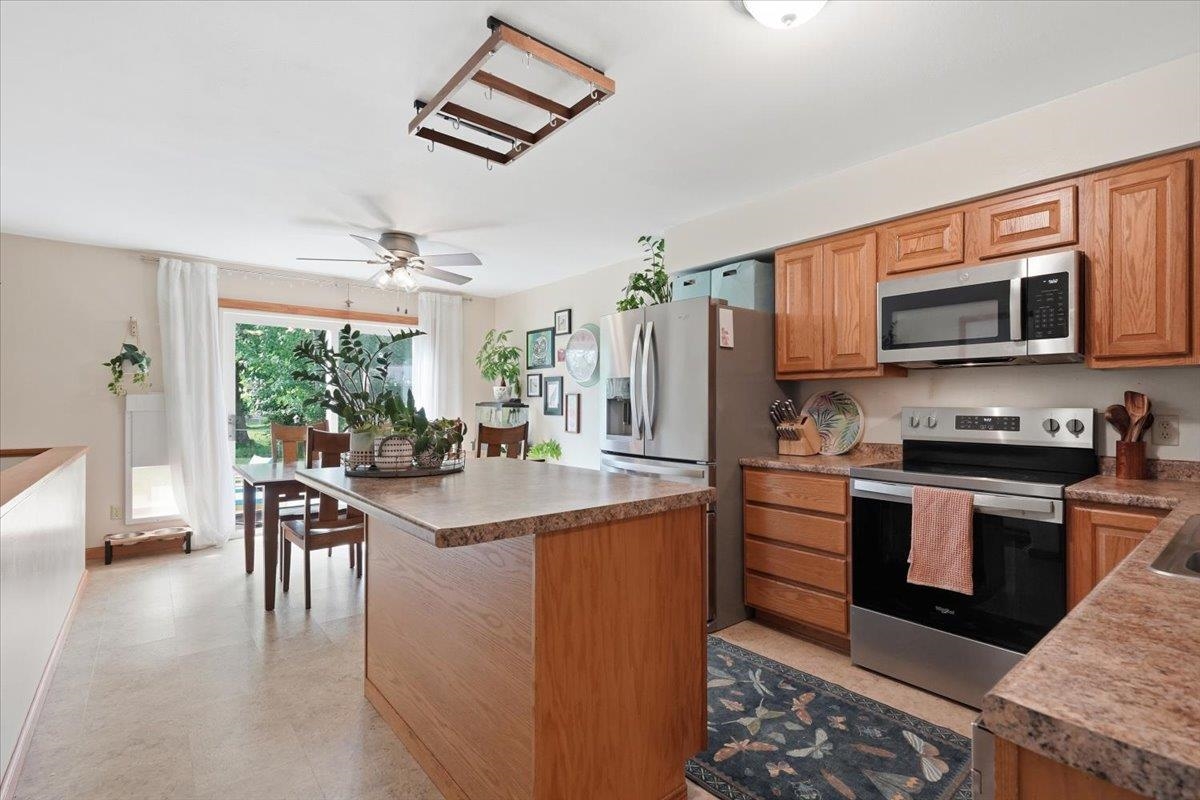 Kitchen with warm wood cabinets, stainless steel appliances, and a large central island.