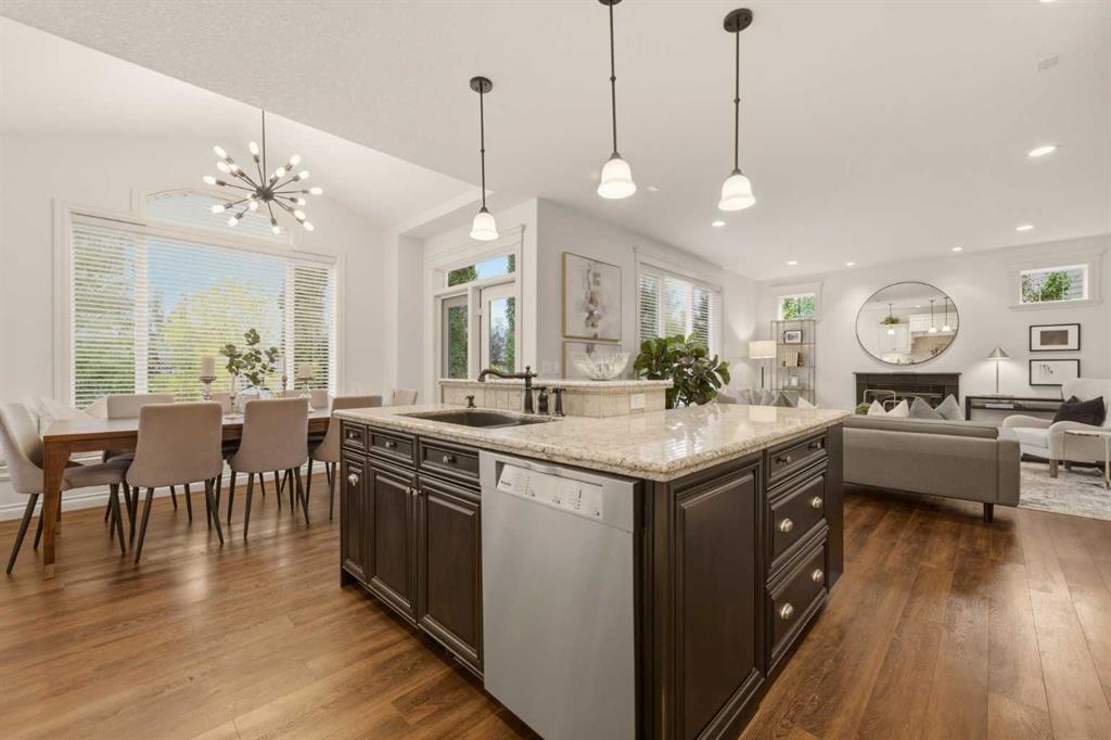 Open-plan kitchen with a large granite island, dining area, and living room beyond.
