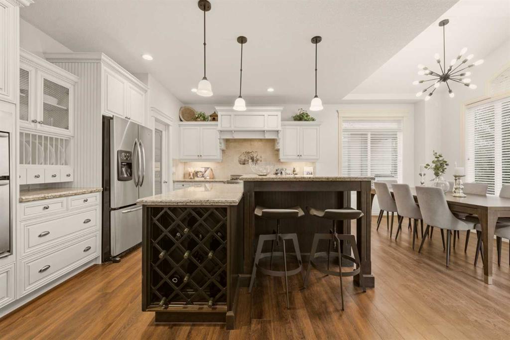 Bright kitchen with white cabinetry, dark wine-rack island, and adjoining dining area.