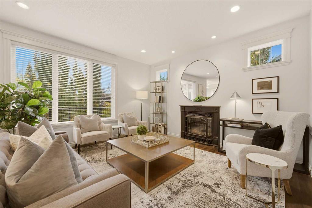 Bright living room with a fireplace, large windows, and neutral seating.