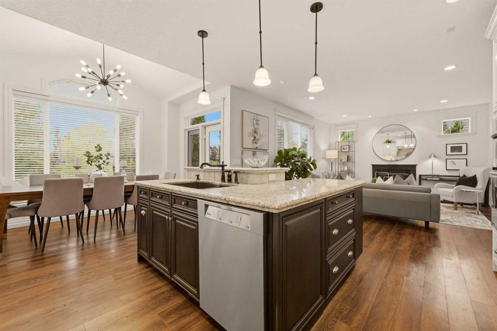 Open-concept kitchen with a large stone-topped island, dining area, and living room.
