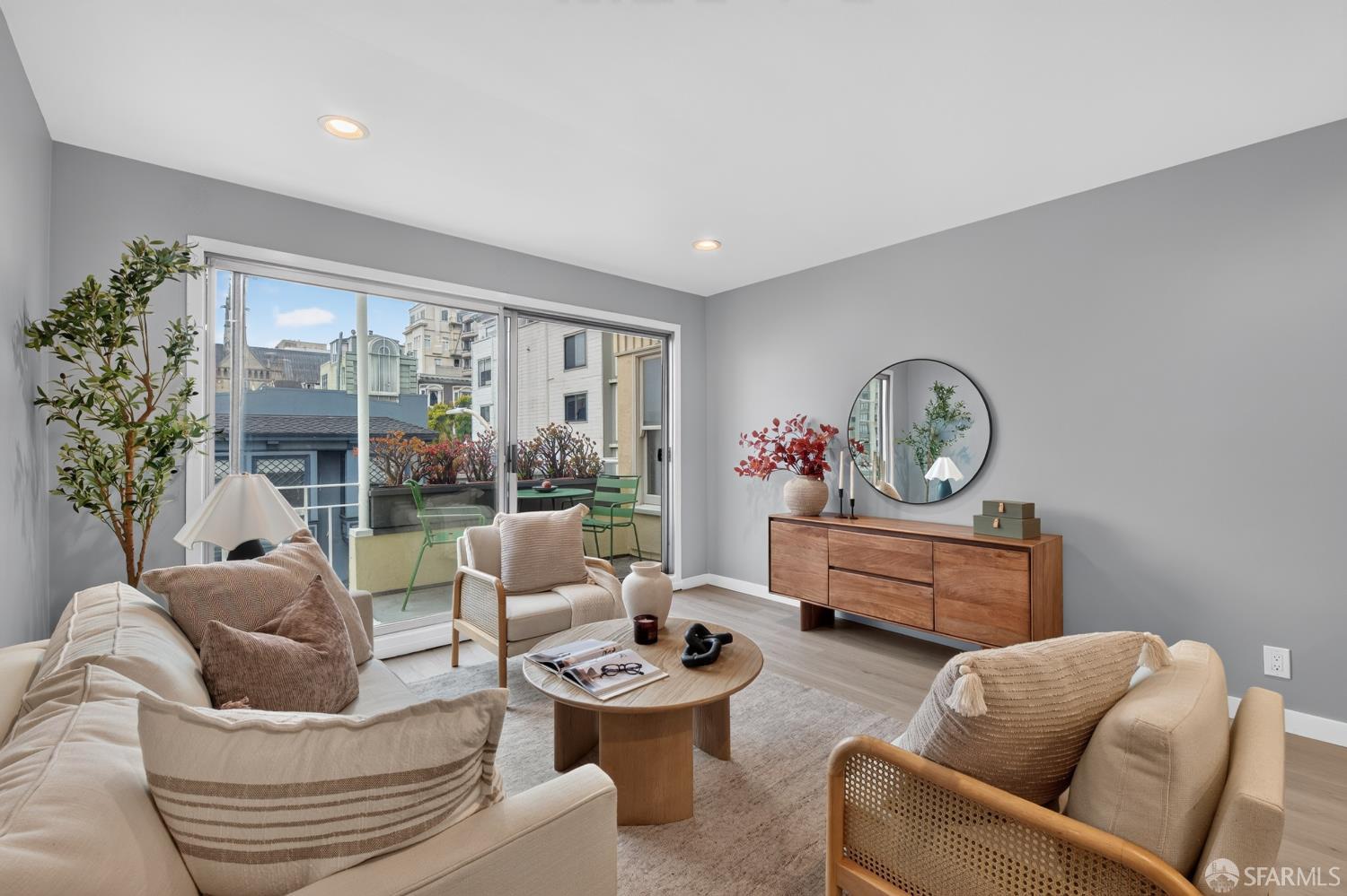 Staged living room with cream seating, a wood coffee table, and sliding doors to a balcony.