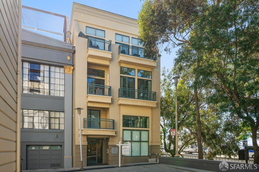 81 Lansing Street residential building with balconies, large windows, and mature trees.