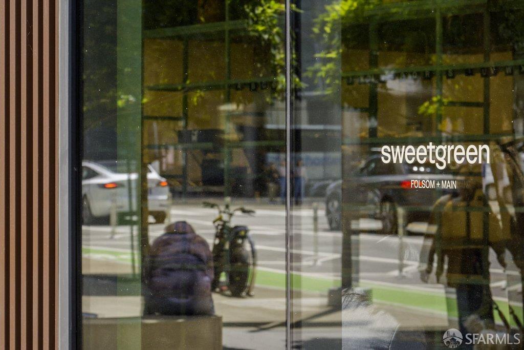 Sweetgreen storefront at Folsom and Main, with street traffic and a bicycle reflected in the glass.