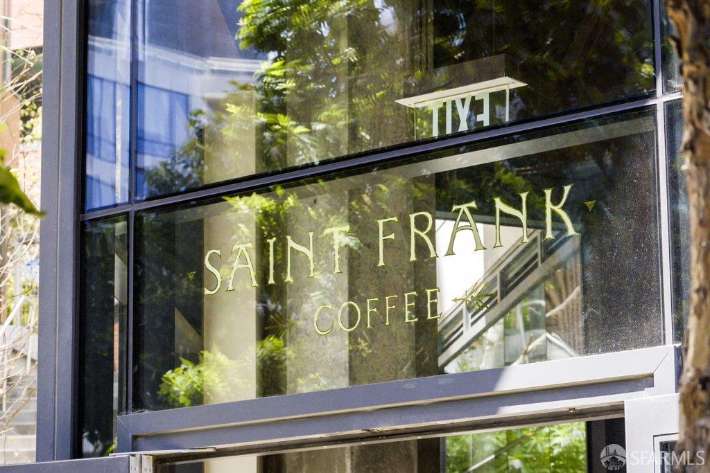 Saint Frank Coffee storefront sign on a reflective glass window