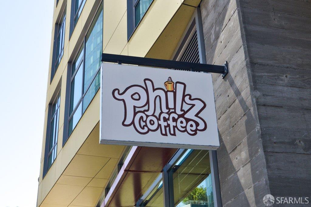 Philz Coffee sign projecting from a modern building facade with large windows.